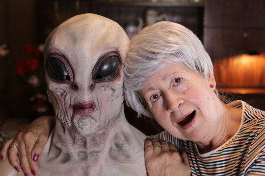 Ecstatic senior woman taking a pic with an alien