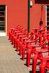Red plastic chairs on the square.