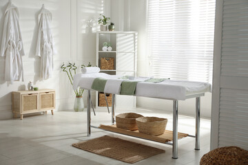 Stylish spa salon interior with massage table