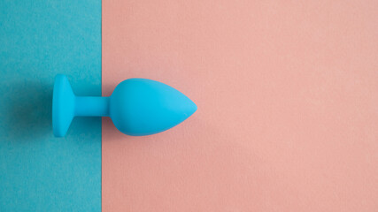 Blue anal plug on a pink background. Plastic sex toy for alternative sex. Copy space.