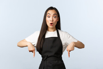 Coffee shop, small business and startup concept. Shocked and impressed asian female barista in...