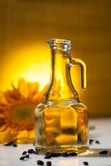 Sunflower oil in a transparent jug with sunflower flower