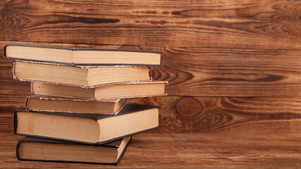 Old shabby books lying on a wooden surface