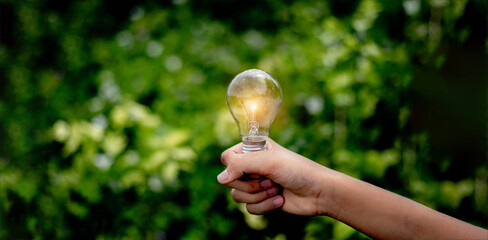 Hand holding light bulb,natural energy and love the world concept.	
