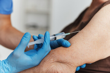 doctor giving an injection to a woman's hand covid-19 vaccination passport