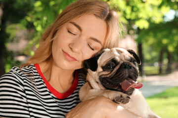 Woman with cute pug dog outdoors on sunny day. Animal adoption