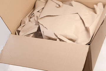 Open gray brown corrugated packing box with wrapping paper inside