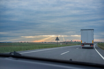 Driving behind  refrigerator truck or chiller lorry at sunset