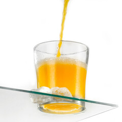 A glass of orange juice on a white background and the corner of the glass table 