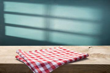 Empty wooden deck with table cloth, napkin over wall background