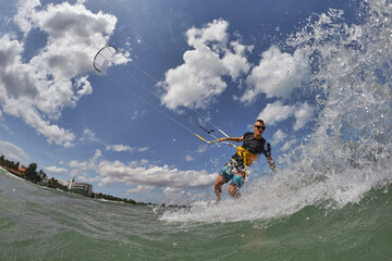 Kite surfer jumps with kiteboard in transition
