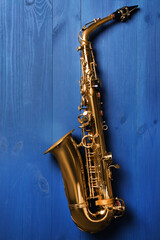 Fototapeta na wymiar Beautiful saxophone on blue wooden background, top view