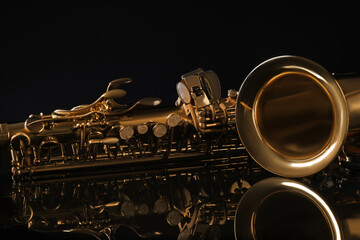 Beautiful saxophone on black background, closeup. Musical instrument