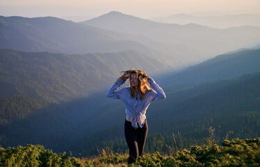 Smiling young cute woman enjoying beauty nature and fresh air. Concept of harmony with nature.