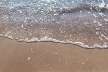 Soft wave of the sea on the sandy evening beach.Soft focus,blurred image.