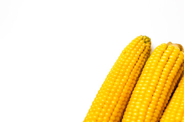 Boiled yellow sweet corn on a white background. Texture. Creative food. Swings of corn. Whole and portions of corn. Ecological food concept. Selective focus