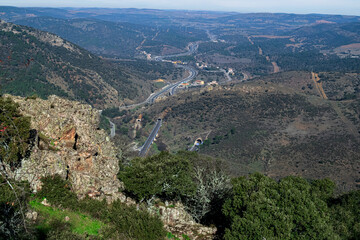 Fototapeta na wymiar View from the top of a hill of the Despeñaperros natural park, of the national highway IV as it passes through the mountains. Photography made in Jaen, Andalucia, Spain. 