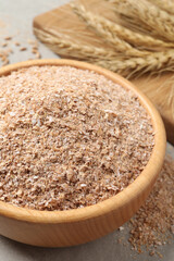 Wheat bran in bowl on table, closeup