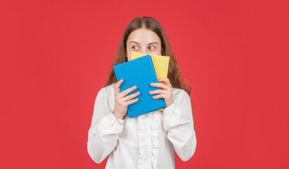 kid in white shirt ready to study do homework behind book on red background, knowledge