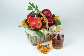 Apples in the basket with Apple juice and Rowanberry on the white background closeup