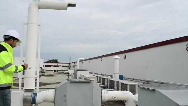 Air conditioning technicians repair and maintain condensing units outside the building, engineers inspect the operation of ventilation fans.