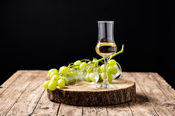 Italian golden grappa drink on rustic wooden table