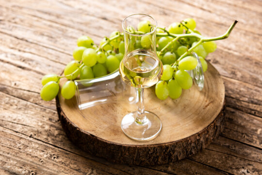 Italian golden grappa drink on rustic wooden table