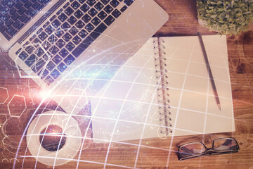 Double exposure of map hologram drawing over study table background with computer. Concept of international network. Top view.