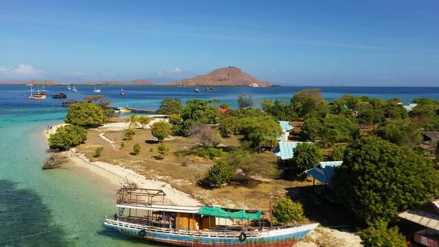 Aerial drone footage of  the stunning Kanawa island with a wreak traditional boat in Komodo area near Labuan Bajo in Flores, Indonesia.