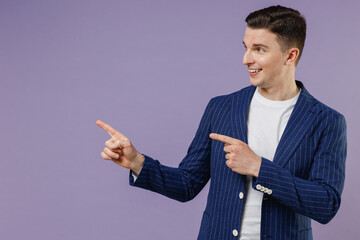 Young business man corporate lawyer 20s wears formal blue suit white t-shirt work in office point on workspace area copy space mock up look aside isolated on pastel purple background studio portrait.