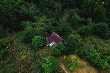 House in the forest. Old wooden house stands in the wild. Aerial view of the home in in thein the woods. Abandoned houses in dead village. Old abandoned countryside.