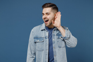 Curious nosy young brunet man 20s wears denim jacket try to hear you overhear listen intently keep...