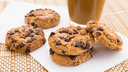 cookies with chocolate and hazelnuts and coffee with milk lie on the table