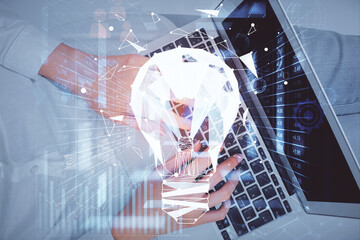 Double exposure of woman hands working on computer and light bulb hologram drawing. Top View. Idea concept.