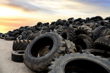 Landfill with old tires and tyres for recycling. Reuse of the waste rubber tyres. Disposal of waste tires. Worn out wheels for recycling. Tyre dump burning plant. Regenerated tire rubber produced.