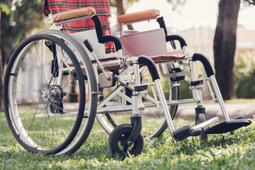 wheelchair on green grass nature background in garden park, wheelchairs travel concept, transporting disabled people using wheels instead of legs.