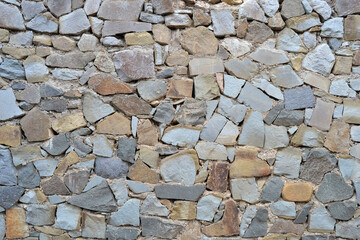 Texture of a stone wall made of natural stone with mosaic masonry for background.