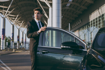 Bottom view full body young traveler brunet businessman man 20s wear black classic tie suit stand...