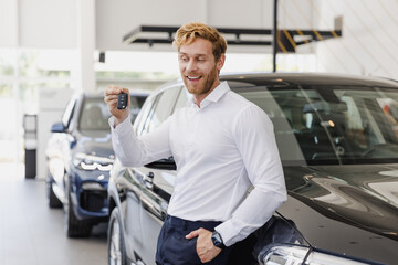 Man customer male buyer businessman client in white shirt hold keys fob chooses auto wants to buy new automobile in car showroom vehicle salon dealership store motor show indoor. Car sales concept