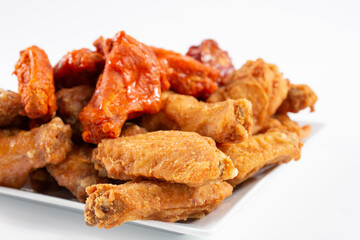 A view of a plate of a chicken wings sampler, featuring flavors as buffalo and BBQ sauce.
