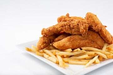 A view of a plate of deep fried chicken strips and french fries. © DAVID