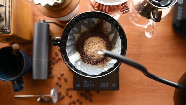 The barista is brewing coffee with traditional drip brewing equipment.