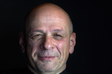 Confident senior man thinking about something. Isolated black background with copy space. Black and White