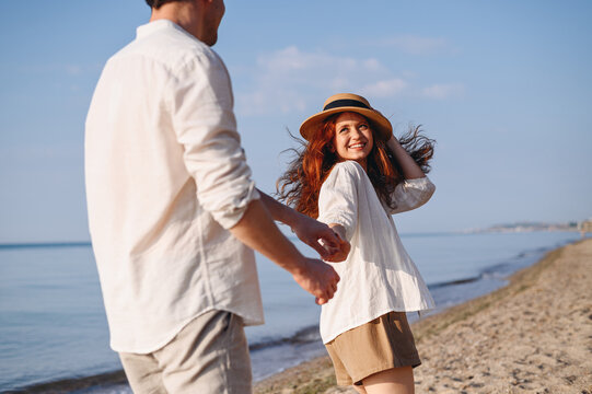 Romantic happy young couple two family man woman in white clothes hold hands follow me look to each other walk together at sunrise over sea beach ocean outdoor exotic seaside in summer day evening.