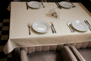 White plate, cutlery and napkin on table