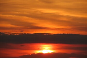 Beautiful fiery orange sunset over the city, the sun sets over the horizon, natural background