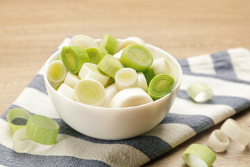 Cut fresh raw leek on wooden table, closeup