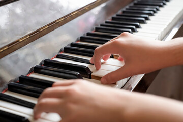 Close-up of a girl playing the piano.