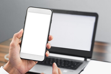 Closeup hand suing mobile smartphone in office work ,phone screen mock up copy spec