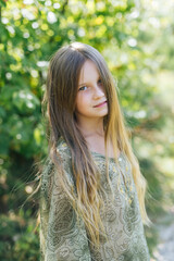 Naklejka premium beautiful attractive stylish girl in a green dress, with long hair romantic mood, posing in summer fashion style, natural look